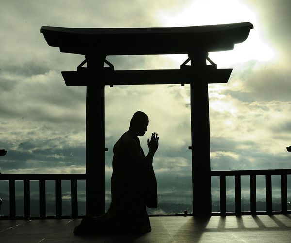 Silhouette of a person meditating at sunrise, symbolizing mindfulness.